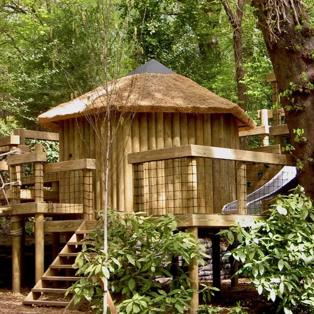 Garden Treehouse set into trees featuring steps and a stainless steel Slide.