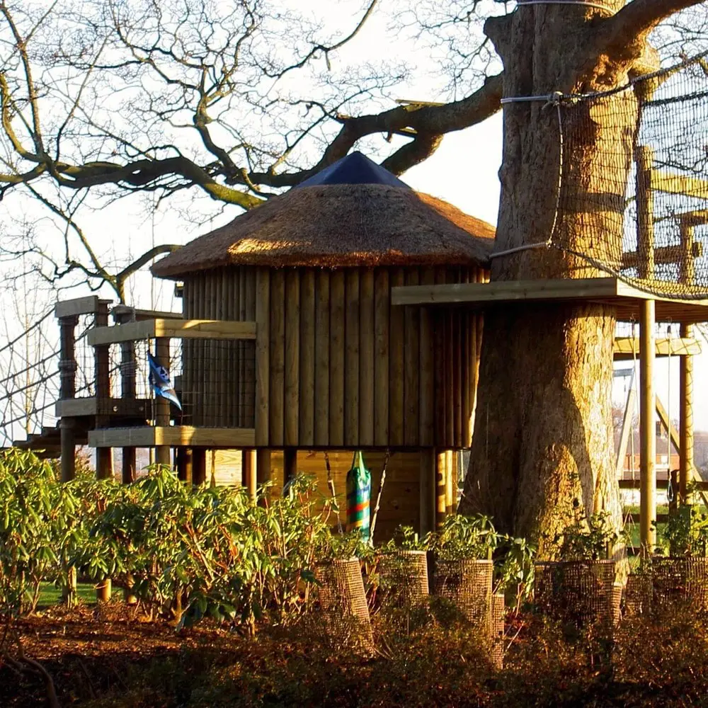 Garden Treehouse featuring a high platform wrapping a tree.