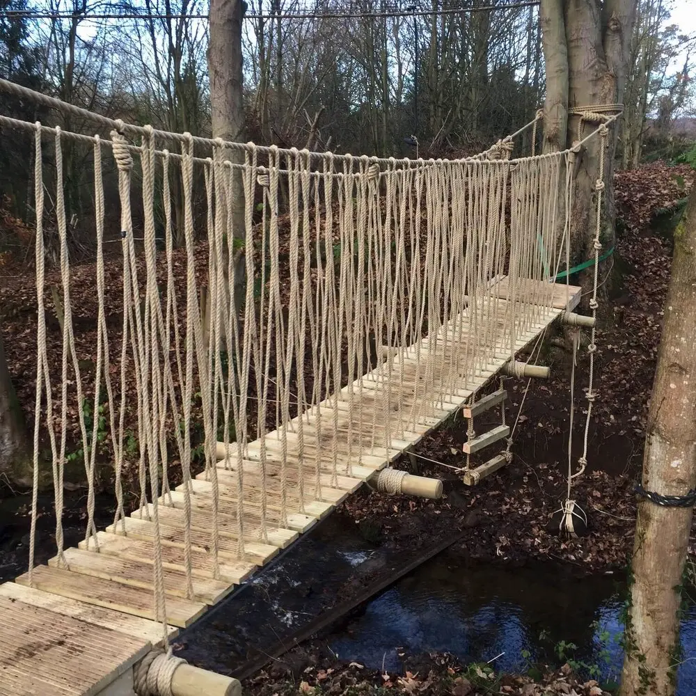 Suspended Rope Bridge set across small stream between two trees.