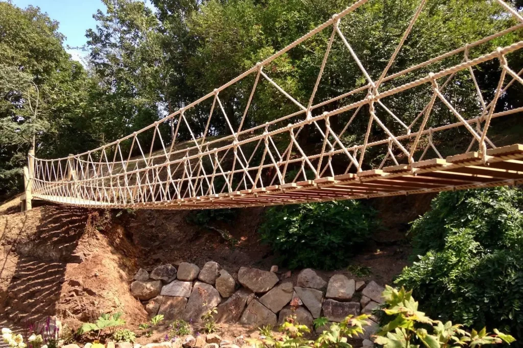 Rope Bridge spanning a rocky pond in a family garden.