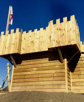Timber Castle Fort for kids with ramparts and flag.