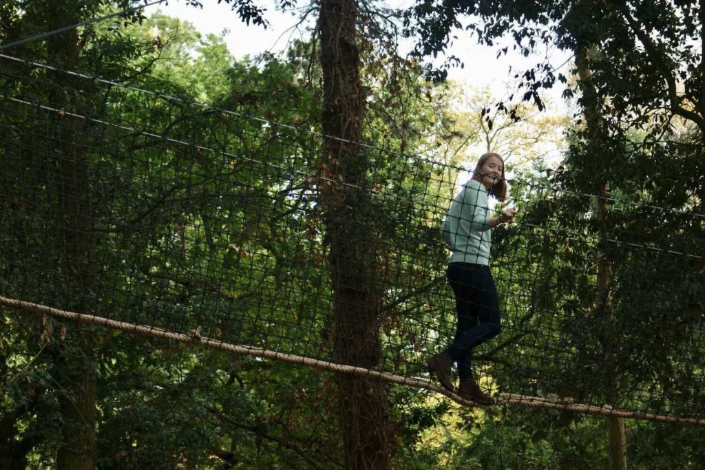 Girl walking in Treetop Walkway between the trees