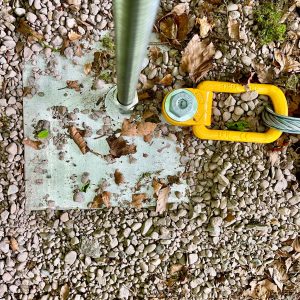 Ground Anchor system with a stainless steel plate at ground surface with stainless steel threaded rod and bolted Swivel Load Ring.