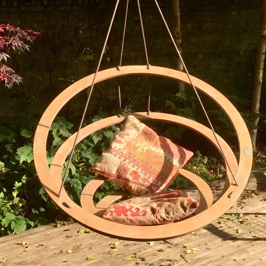 Round Nest Swing with two cushions suspended over a garden deck