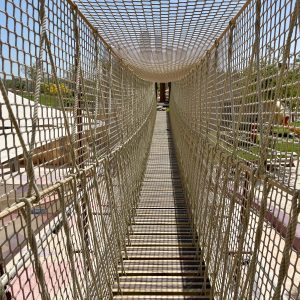 Looking through and into Rope Bridge in Doha, Qatar with safety netting to balustrades and above head and structural rope within balustrade both sides.