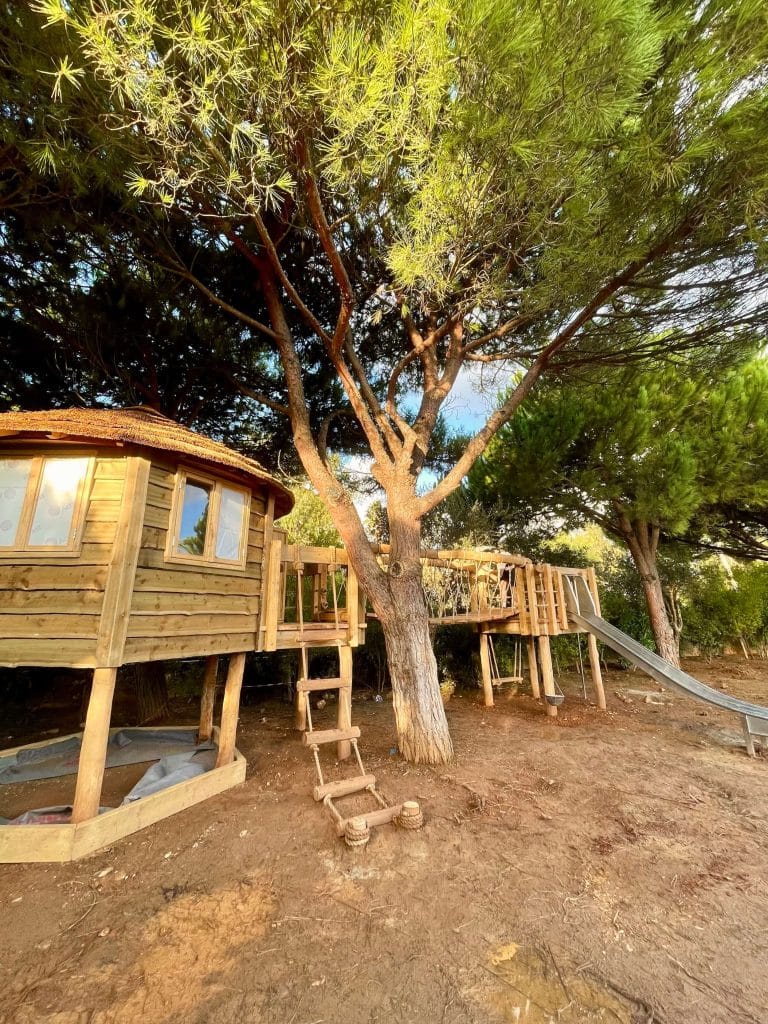 Treehouse with Rope Ladder, Balcony, Rope Bridge, Deck Platform and stainless steel Slide in family garden.