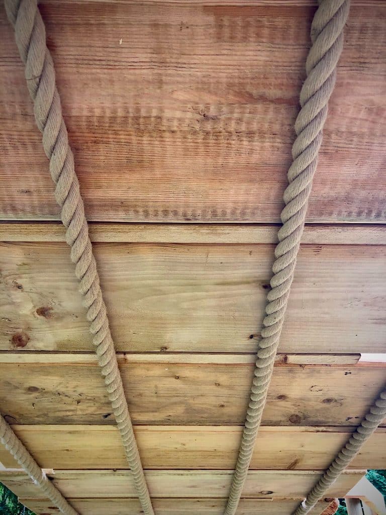 A timber climbing wall and four climbing ropes.
